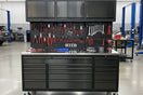 Garage workbench with tool storage, drawers, overhead cabinets, and organized hand tools