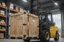 Forklift moving large wooden crate in warehouse with storage shelves and boxes.