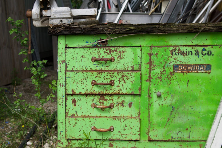 a green cabinet with a bunch of junk on top of it
