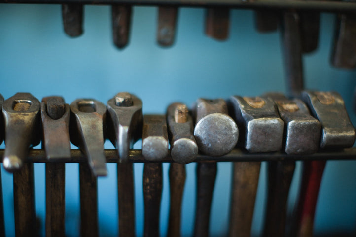 a row of metal tools sitting on top of a wooden rack