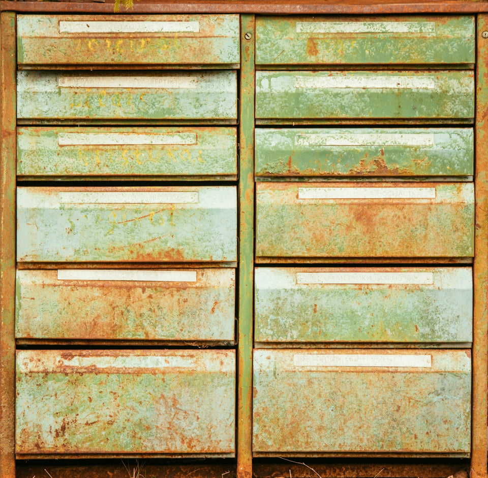 an old rusty green dresser sitting on top of a grass covered field