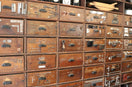 A wall of antique drawers filled with hardware.