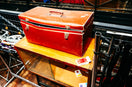 A red toolbox rests on a wooden cabinet.